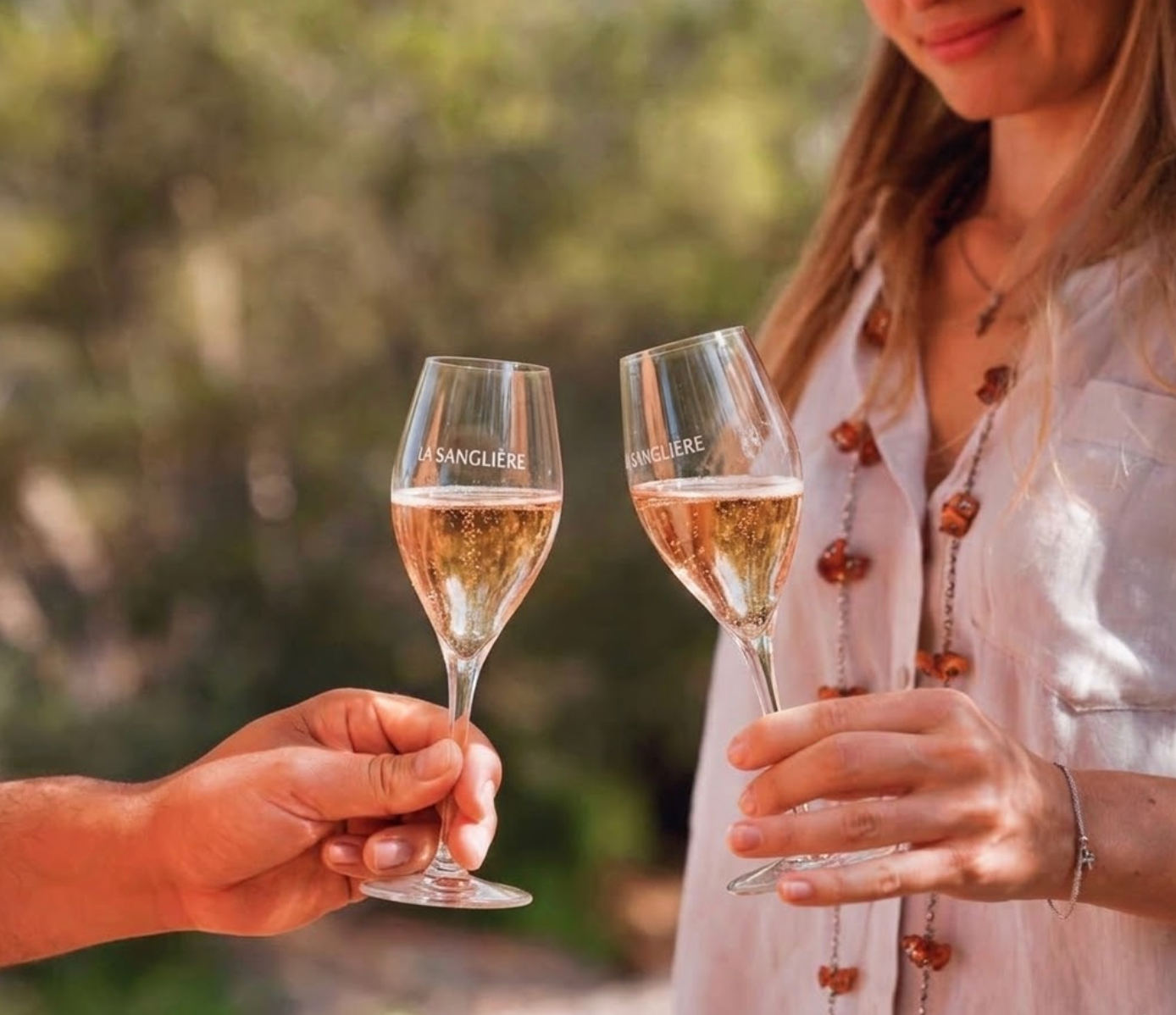 Moment de convivialité et dégustation de vin dans des verres gravés au nom du Domaine de la Sanglière. Un apéritif d'exception à Bormes-les-Mimosas, illustrant l'art de vivre en Provence entre mer, soleil et vignobles.
